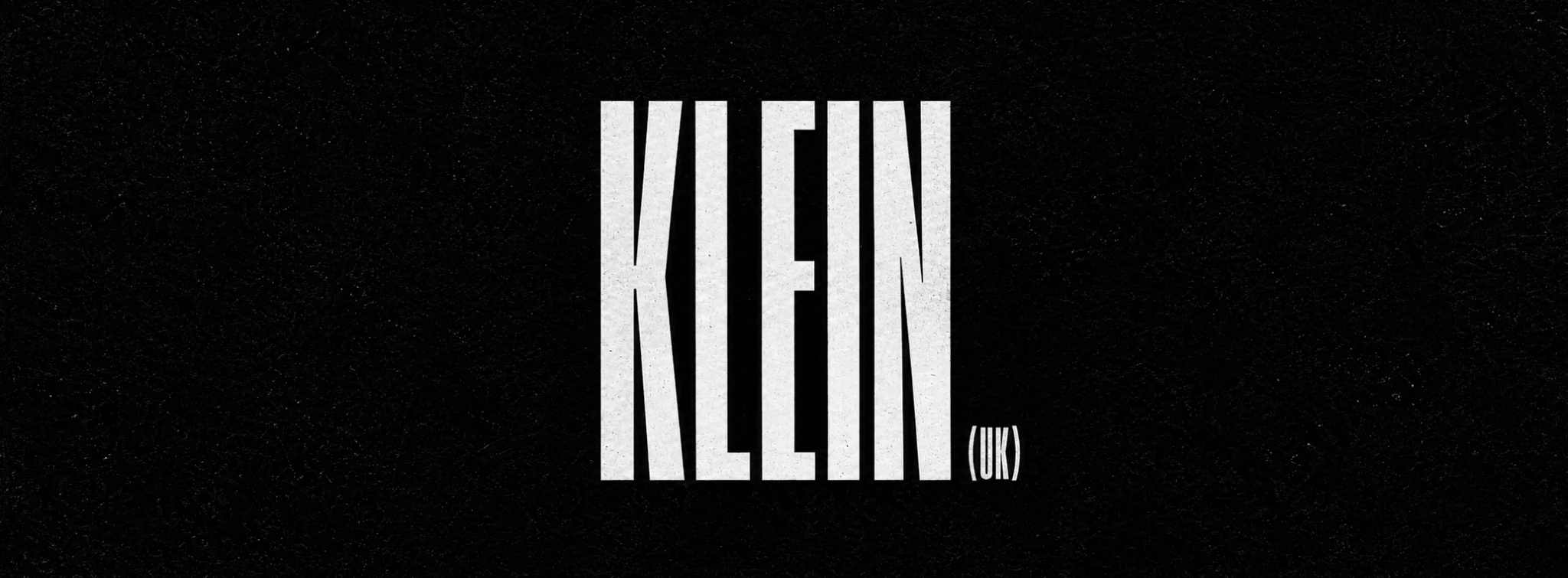 KLEIN (UK) monochrome wordmark on textured black